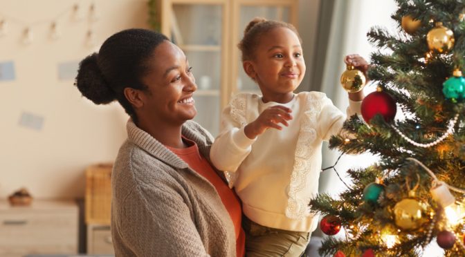 Mother and daughter decorating Christmas tree