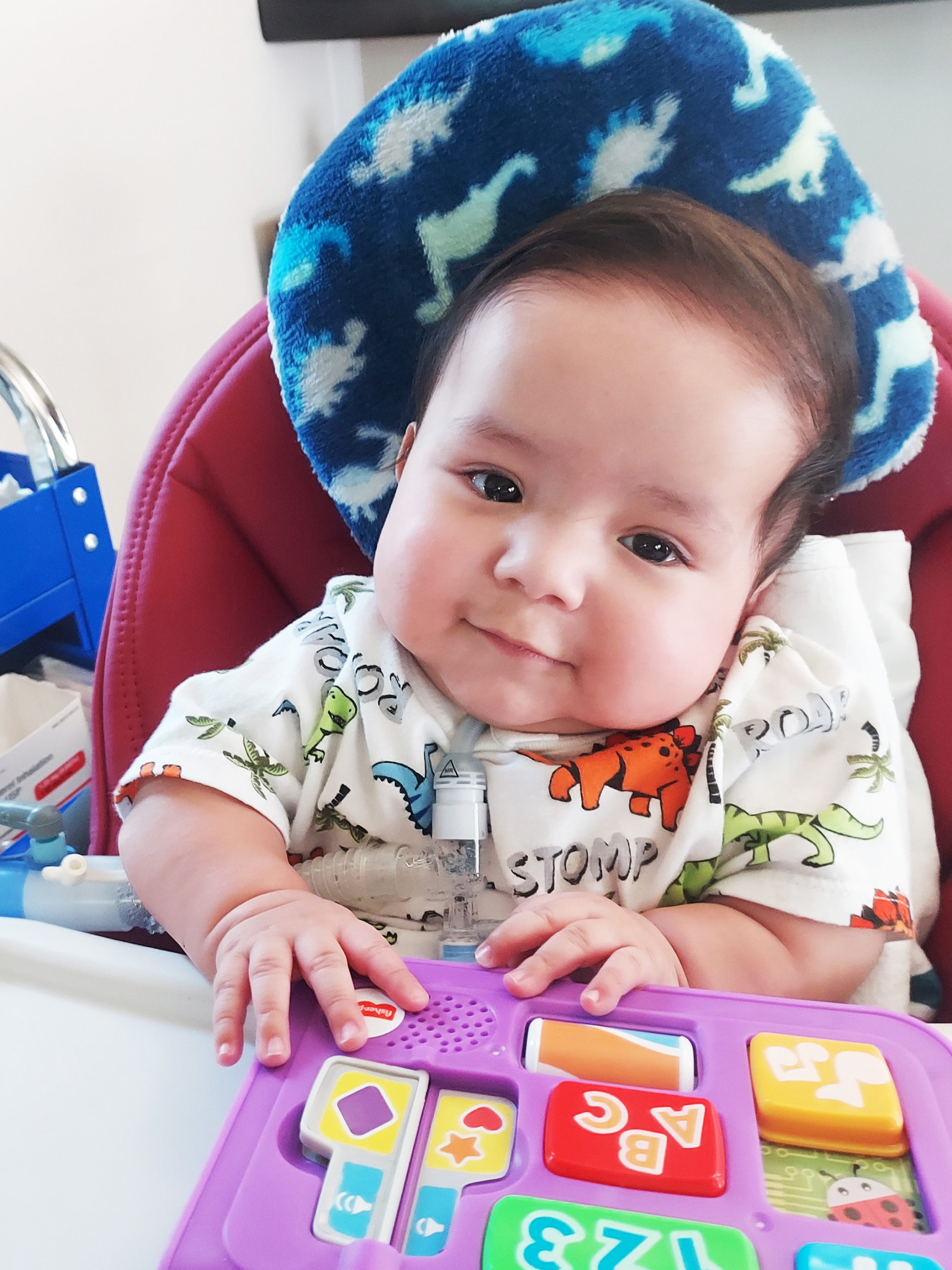 Freddy looks at the camera and smileswhile playing with a puzzle